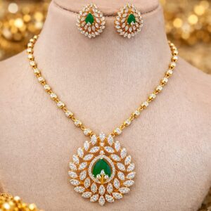 Emerald green CZ peacock design locket necklace with matching earrings on plain white background