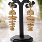 Gold plated layered jhumka earrings with green stone stud and crystal detailing
