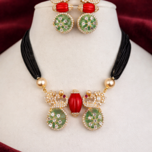Gold plated black thread necklace set with green stones, red centerpiece and matching earrings